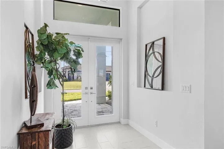 Foyer entrance featuring french doors, light tile patterned flooring, and plenty of natural light