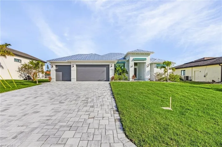 View of front of home with central AC, a front yard, and a garage