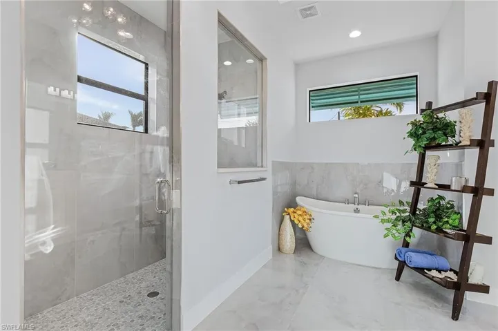 Bathroom featuring separate shower and tub and a healthy amount of sunlight