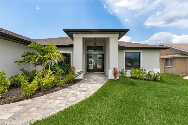 View of exterior entry with a yard and french doors