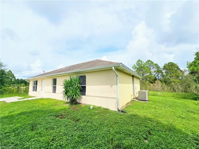 View of home's exterior featuring a yard and stucco siding