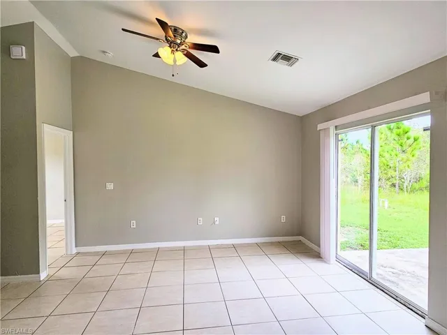 Spare room with light tile patterned floors, ceiling fan, and vaulted ceiling