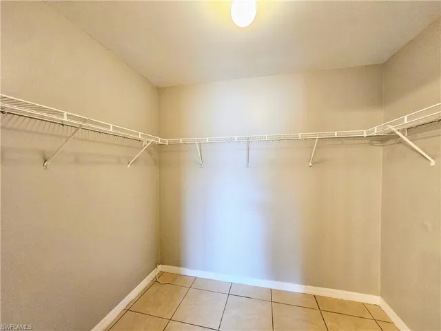 Spacious closet with light tile patterned floors
