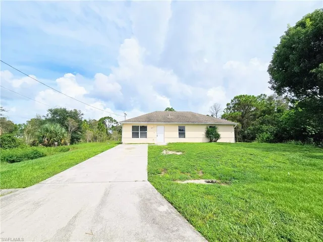 Single story home with driveway and a front yard