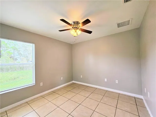 Spare room with light tile patterned flooring and ceiling fan