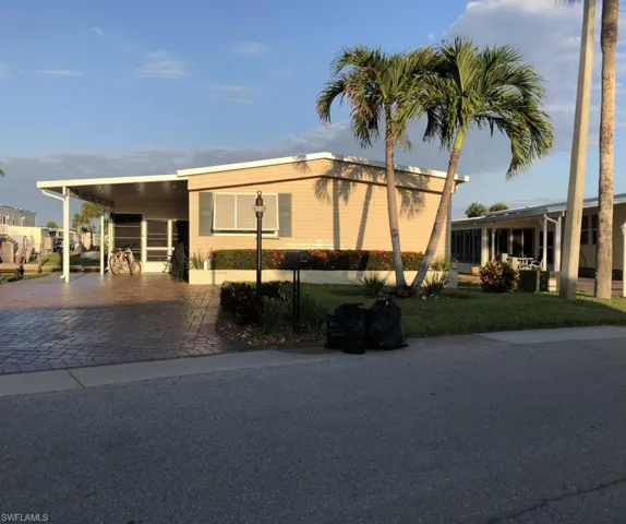 View of front of property with a front lawn and a carport