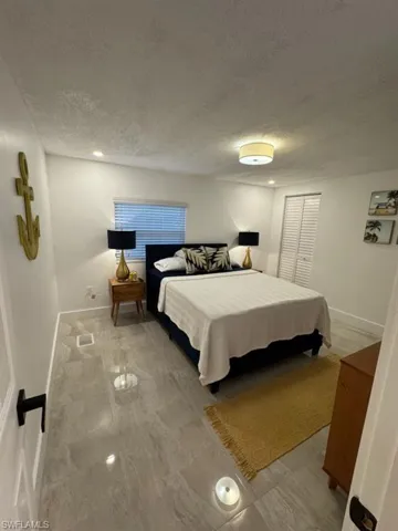 Bedroom with tile flooring and a textured ceiling