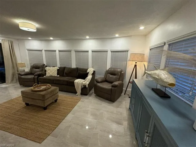 Living room with a textured ceiling and light tile floors
