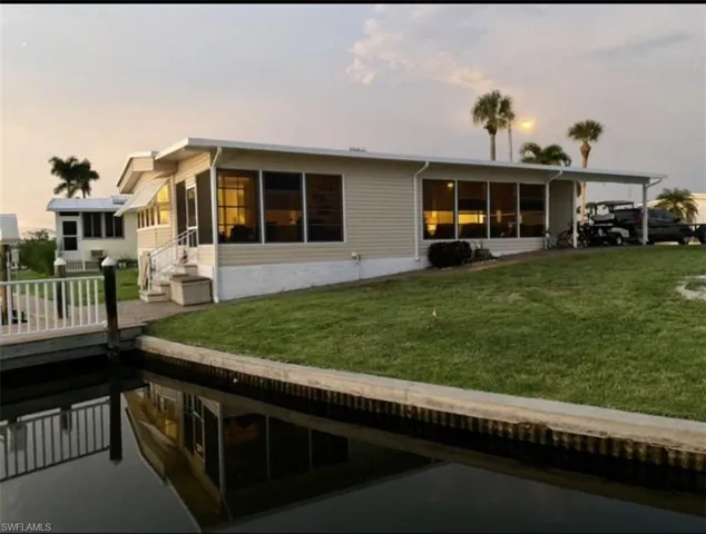Back house at dusk with a yard