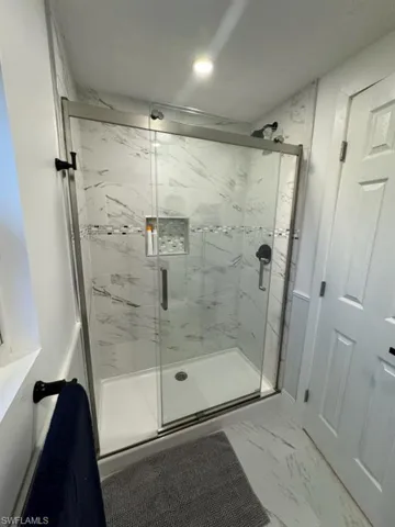 Bathroom with tile floors and an enclosed shower