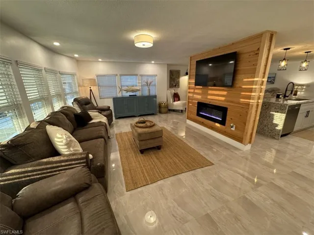 Living room featuring a healthy amount of sunlight, sink, and light tile floors
