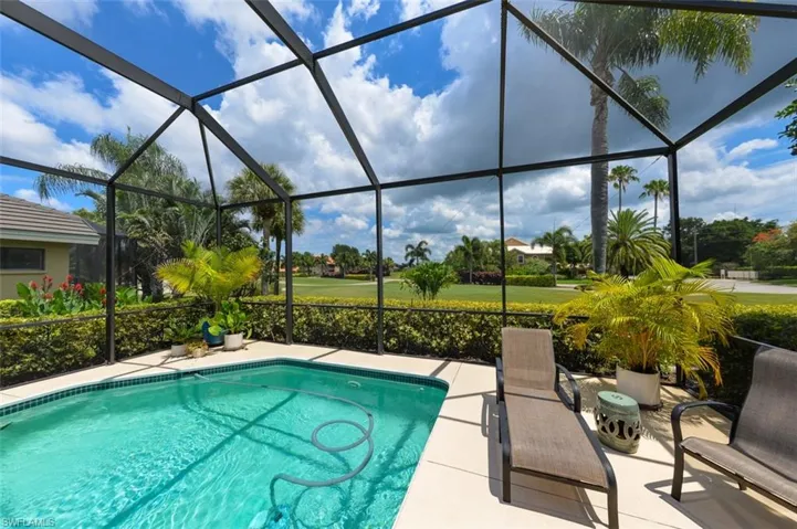 View of pool with glass enclosure and a patio area
