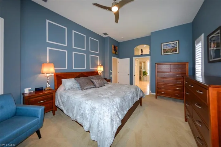 Bedroom with ceiling fan and light colored carpet