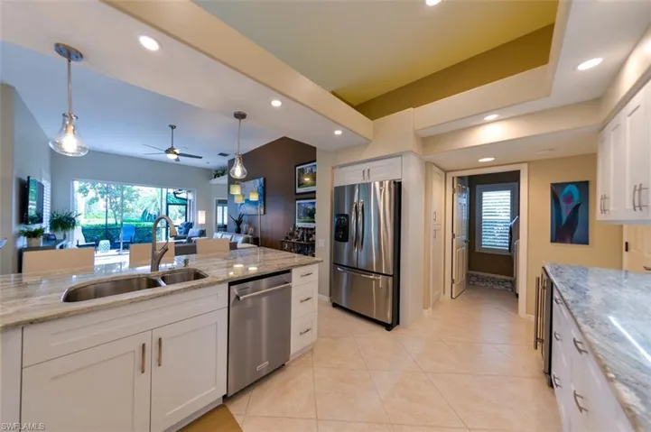 Kitchen with appliances with stainless steel finishes, white cabinets, sink, ceiling fan, and light tile floors