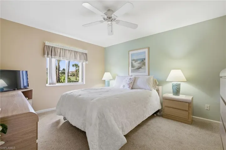 Bedroom with a ceiling fan and light colored carpet