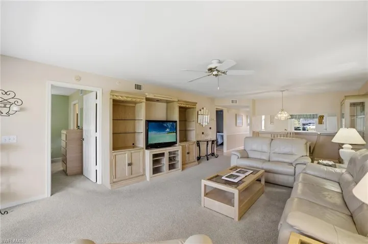 Living room with carpet flooring and ceiling fan