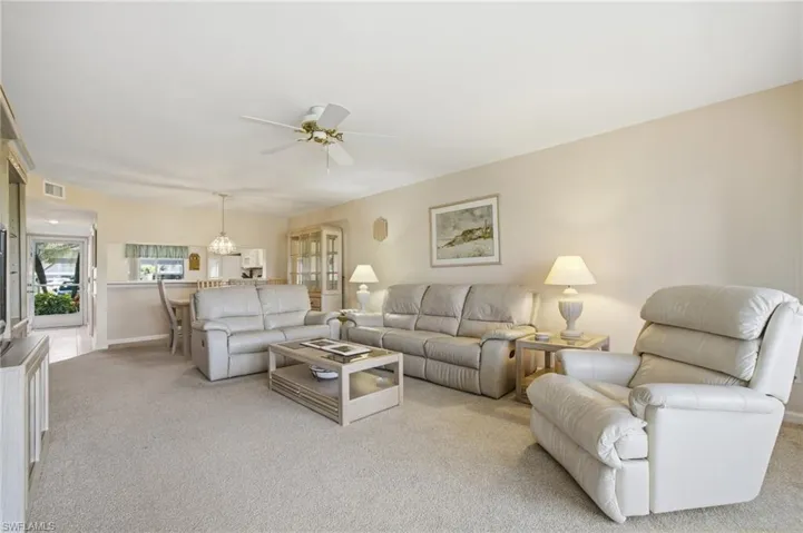 Living area with carpet floors and ceiling fan