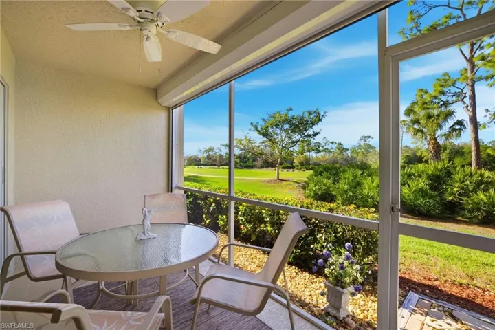 Sunroom featuring ceiling fan, view of golf course, and outdoor dining area