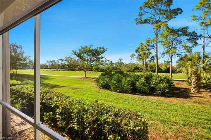 View of green lawn with view of golf course