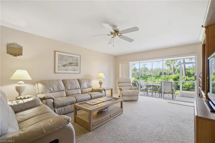 Living room featuring light carpet and ceiling fan