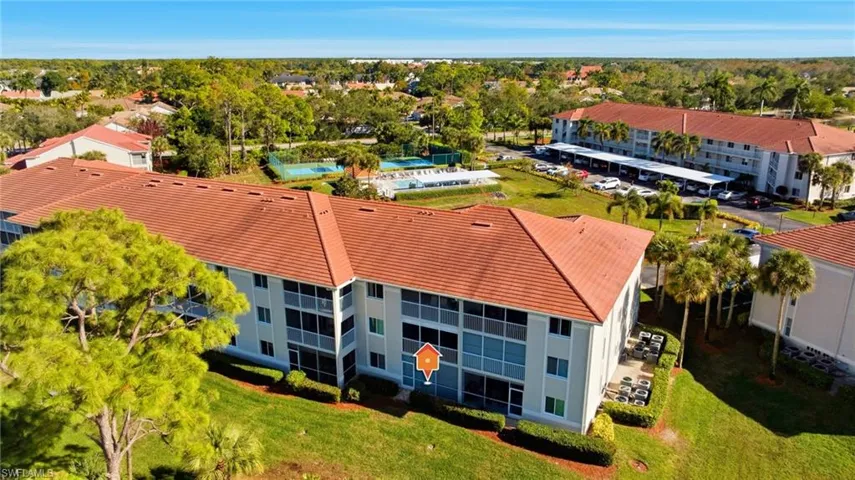 Drone / aerial view of apartment complex / building and a tree filled landscape