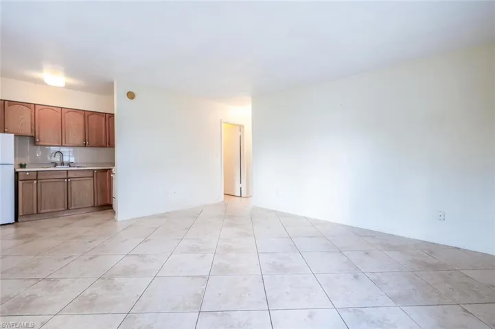 Unfurnished living room featuring light tile patterned floors and a sink