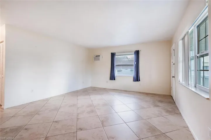 Spare room featuring light tile patterned floors and a wall mounted AC