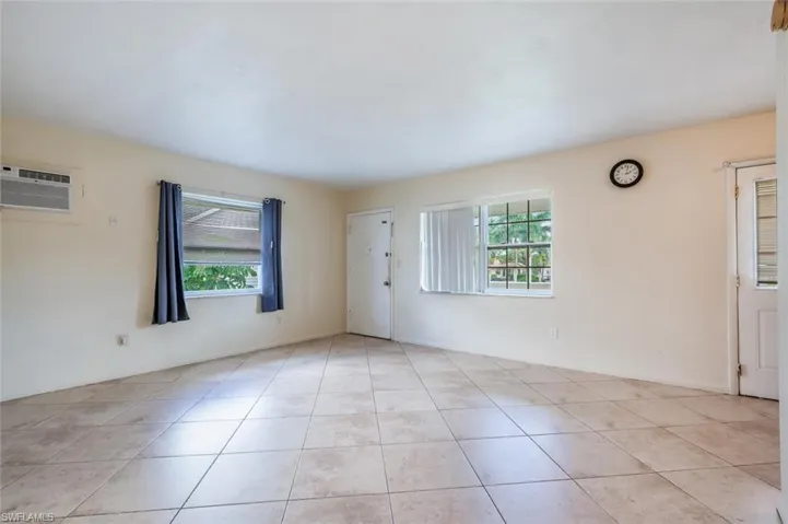 Tiled spare room with a wall mounted AC