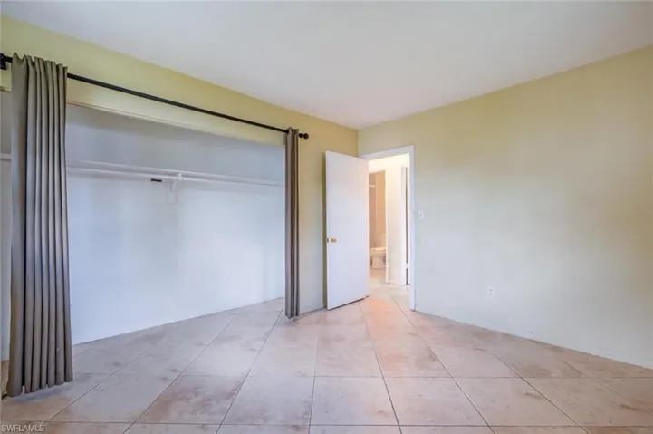 Unfurnished bedroom featuring light tile patterned floors and a closet