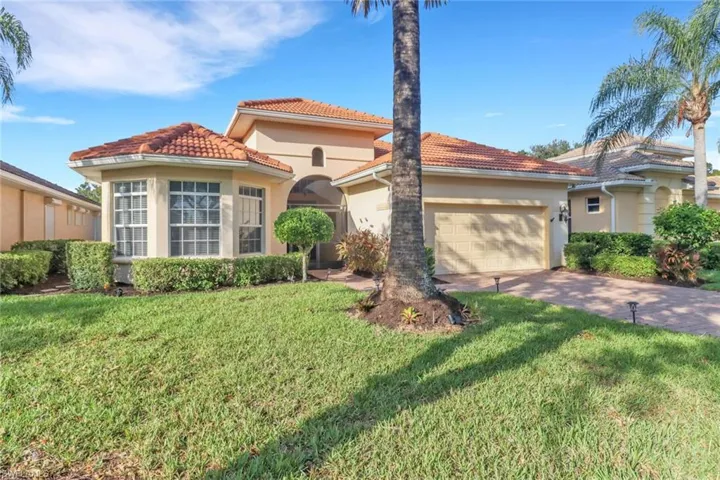 Mediterranean / spanish-style house featuring a front lawn and a garage