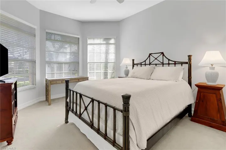 Bedroom with ceiling fan and light carpet