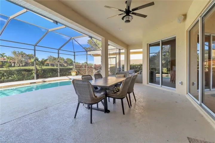 View of pool featuring a screened lanai and ceiling fan