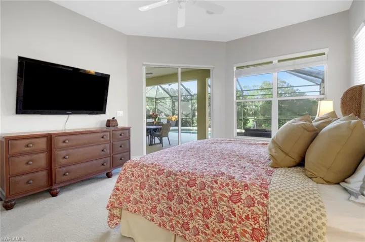 Carpeted bedroom featuring ceiling fan, access to outside, and multiple windows