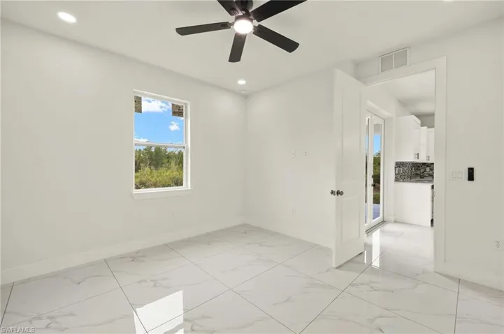 Empty room with baseboards, light marble finish floors, recessed lighting, and ceiling fan