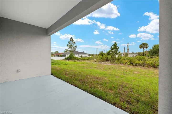 View of grassy yard featuring a patio area