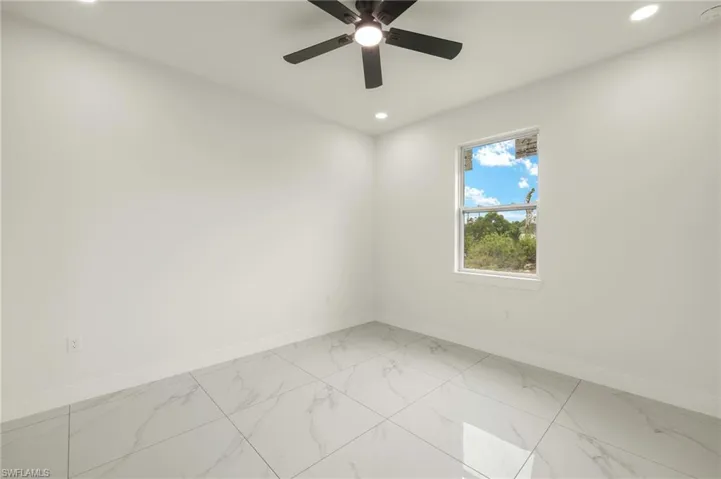 Unfurnished room with recessed lighting, baseboards, light marble finish flooring, a ceiling fan, and a smoke detector