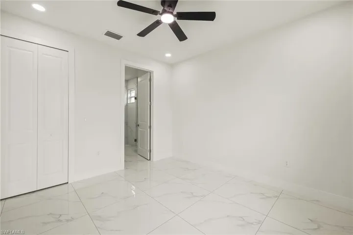 Unfurnished bedroom featuring baseboards, light marble finish floors, recessed lighting, a closet, and ceiling fan