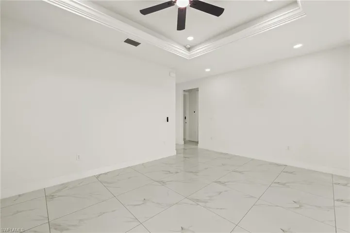 Unfurnished room with light marble finish flooring, baseboards, recessed lighting, ceiling fan, and crown molding