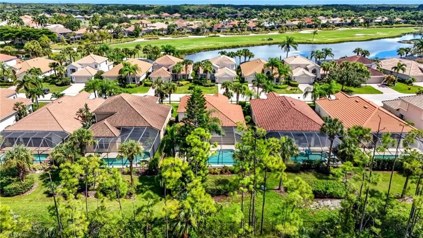 Aerial perspective of suburban area with a nearby body of water and a golf club