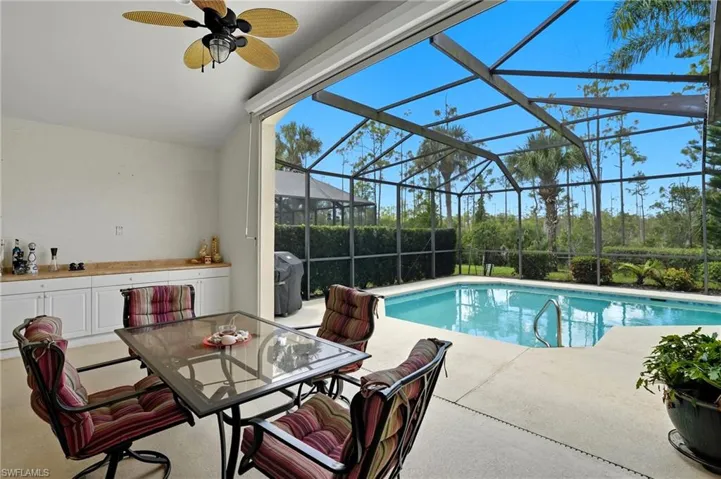 View of swimming pool featuring a sunroom, a patio area, ceiling fan and grilling area