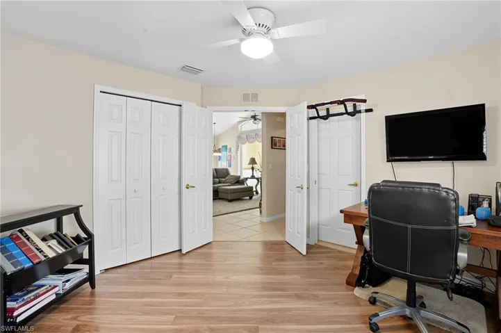 Office with light wood finished floors; on-suite bath