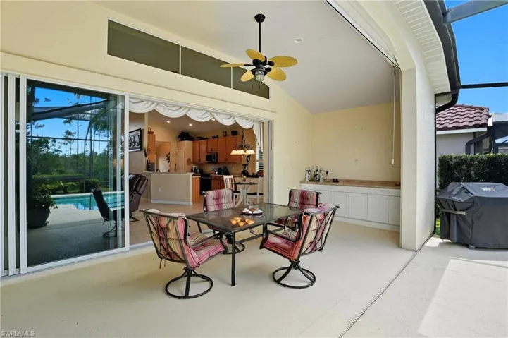 View of patio featuring a ceiling fan, a grill, a lanai, outdoor dining space, and storage area