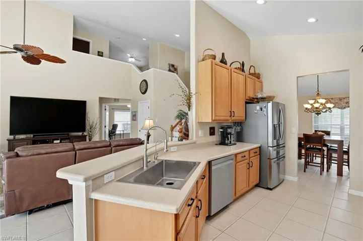 Kitchen featuring open floor plan, light countertops, light tile patterned floors, stainless steel appliances, and high vaulted ceiling