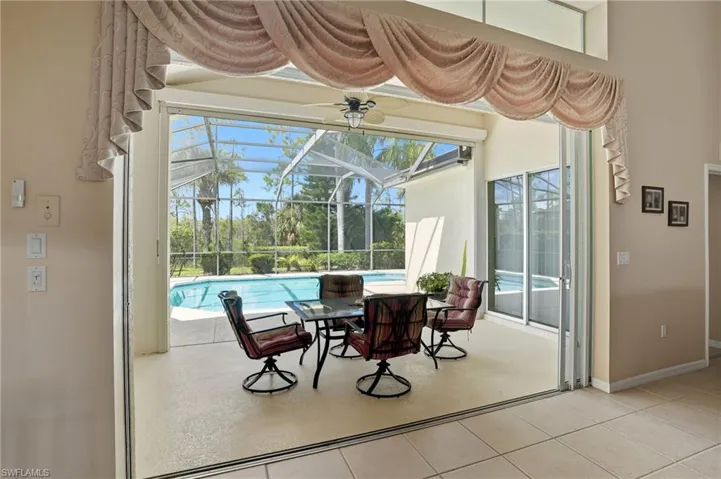 View of patio / terrace featuring a sunroom, an outdoor pool, a ceiling fan, and a lanai
