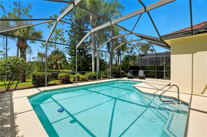 Swimming pool with screen enclosure, a patio, and a covered lanai