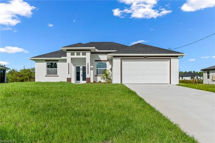Prairie-style home with a front yard and a garage