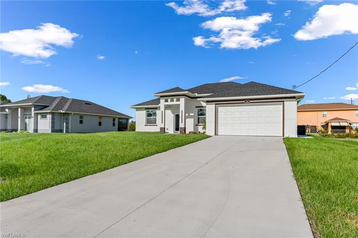 View of front of home featuring a garage and a front lawn