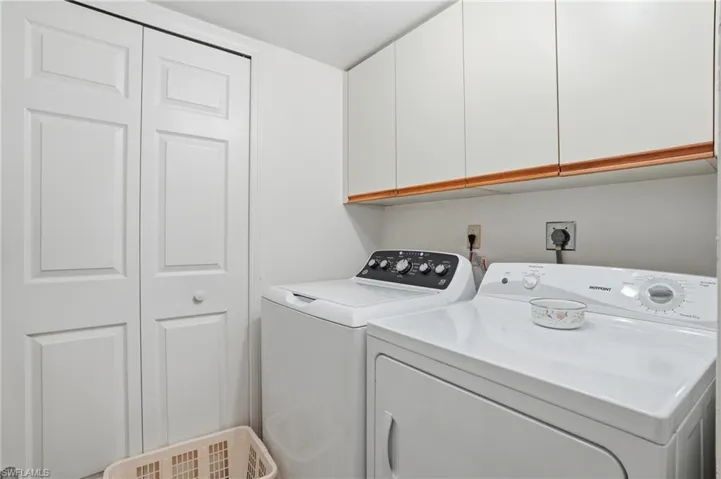 Laundry area featuring independent washer and dryer and cabinet space