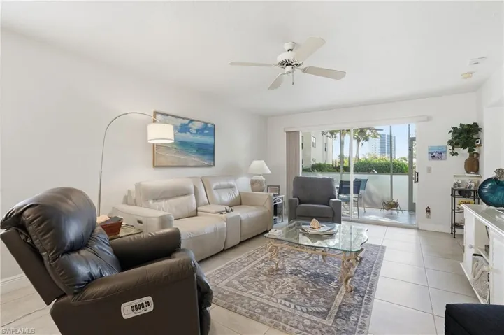 Living area featuring a ceiling fan and light tile patterned flooring