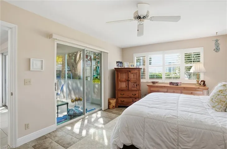 Bedroom with multiple windows, access to outside, and ceiling fan